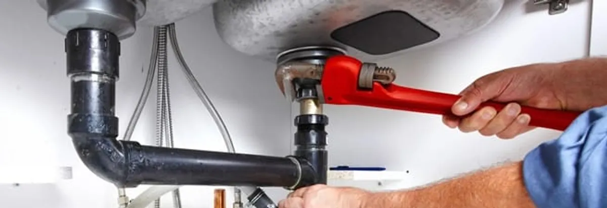 Garbage disposal repair technician tightening the sink drain and disposal connection in Milwaukee, WI